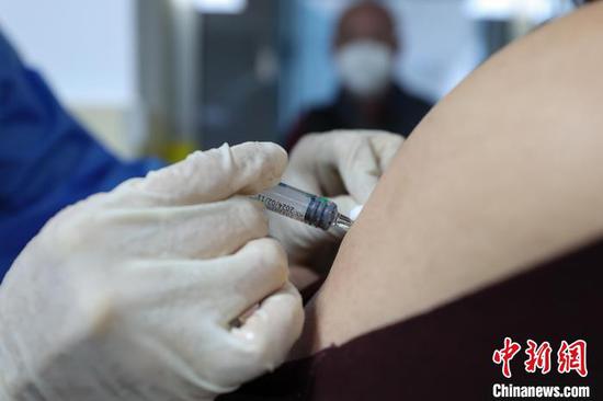 12月23日，遵义市新蒲新区康华医院疫苗接种点内，医护人员在为市民进行第二剂次加强免疫接种。　瞿宏伦　摄