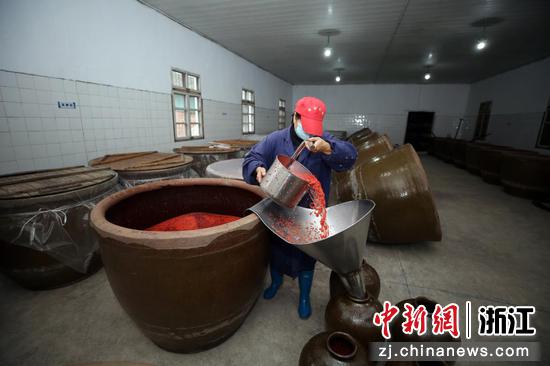 酿酒师傅将在大酵缸中发酵4、5天后的红曲酒舀出运到室外低温发酵。 胡扬辉 摄