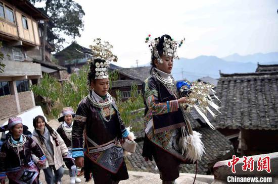 在贵州省榕江县兴华乡摆贝苗寨，苗族妇女前去参加鼓藏节活动。　王炳真 摄