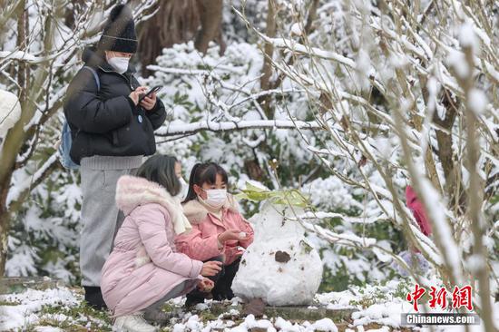 图为市民在贵阳观山湖公园内推雪人。 瞿宏伦 摄