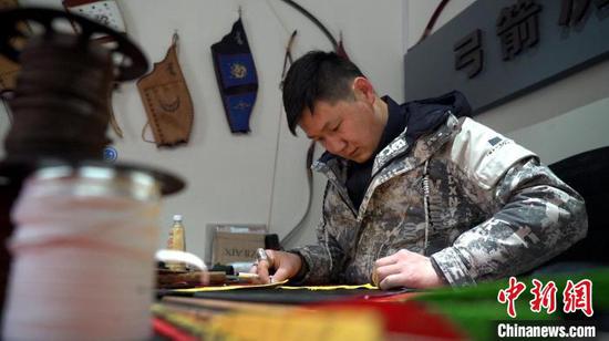察县90后锡伯族传统弓箭制作手工艺人赵虎正在制作弓箭袋。　苟继鹏　摄