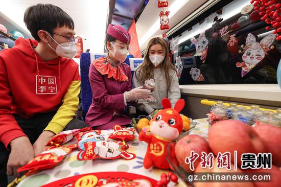 列车员张志萍在给旅客介绍腊八粥的配料。 瞿宏伦 摄