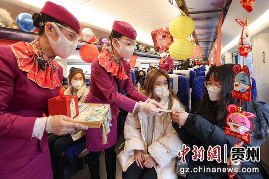 列车员在给旅客赠送新年书签礼品。 瞿宏伦 摄