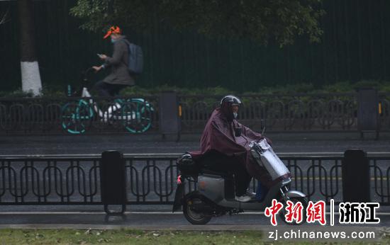 市民穿雨衣骑车出行。 王刚供图