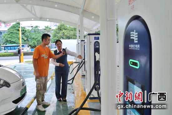 柳州融安县综合能源服务站内，服务人员指导客户充电。陆雯  摄