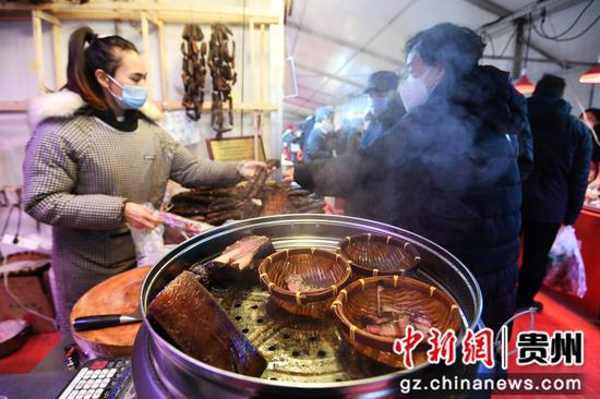 12月31日，市民在贵阳市南明区2023幸福中国-贵阳第八届迎春年货节集市选购腊味食品。