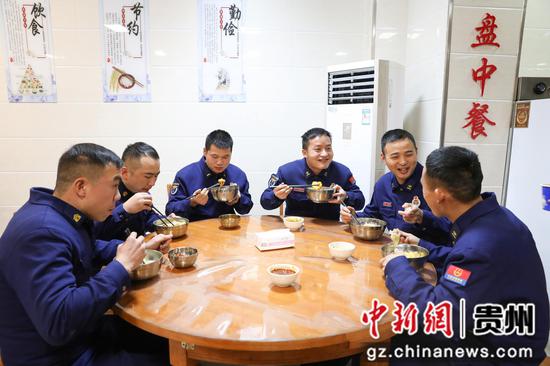 消防员们围坐在一起，吃着热腾腾的饺子。刘梦摄