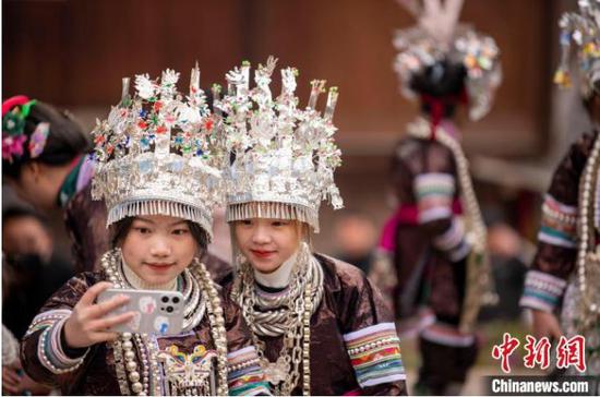 在贵州省从江县下江镇秋里苗寨，苗族姑娘在芦笙节活动上用手机自拍。　吴德军 摄