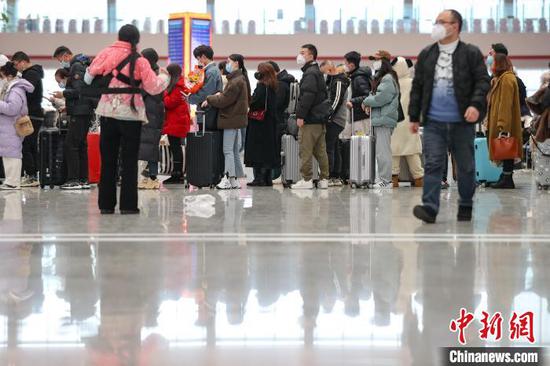 旅客在贵阳北站候车大厅排队等待检票。　瞿宏伦 摄