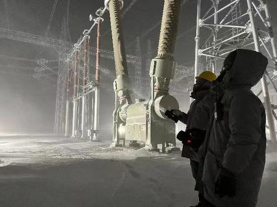 2022年11月26日，国网新疆超高压分公司员工在750千伏喀纳斯变电站进行极寒天气设备特巡工作。董辉 摄