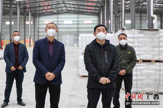 金秀县委书记谭玉成（左三）一行参观企业生产车间。  黄珊珊  摄