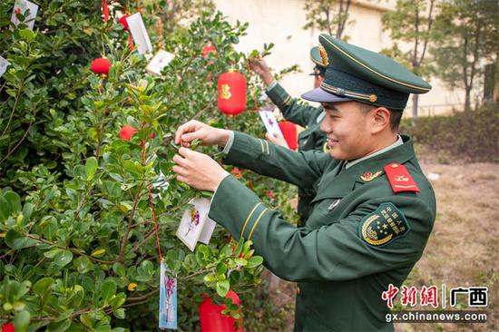 1月5日，一名战士将自己的心愿卡挂在“许愿树”上。