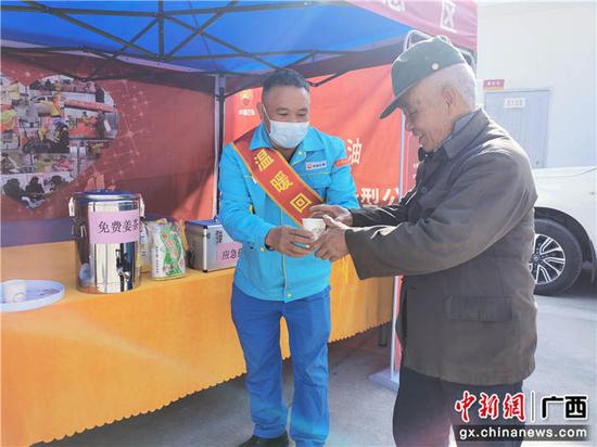 工作人员给返乡者送姜茶暖身。中国石油广西销售公司供图