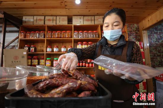 图为一位工作人员在打包香肠。 瞿宏伦 摄 图为一位工作人员在打包香肠。 瞿宏伦 摄