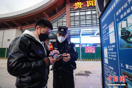 1月9日，贵州贵阳，谢源在贵阳东站指导旅客办理临时身份证明。 瞿宏伦 摄