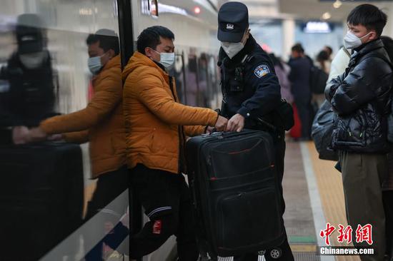 1月9日，贵州贵阳，谢源在贵阳东站月台帮助下车旅客搬运行李。 瞿宏伦 摄