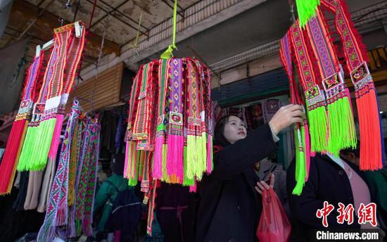 苗族同胞在贵州省丹寨县民族服装市场选购制作苗族服装的饰带。　黄晓海 摄