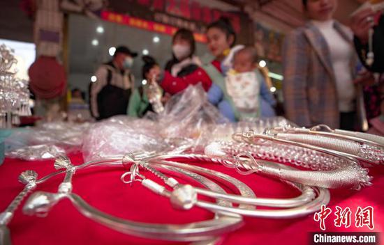 苗族同胞在贵州省丹寨县民族服装市场选购银饰。　黄晓海 摄