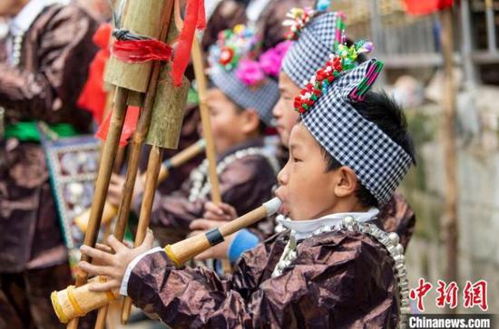 苗族小朋友在贵州省从江县丙妹镇大塘村的芦笙节上吹奏芦笙。　吴德军 摄
