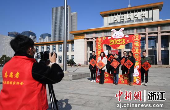 
摄影志愿者为留杭外来务工者等人拍摄新年合影。  王刚 摄