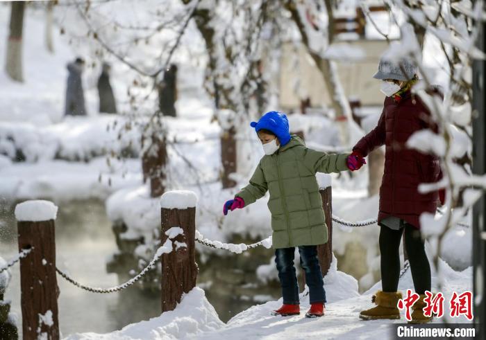 乌鲁木齐市民带着小朋友公园里赏雪景。　刘新　摄