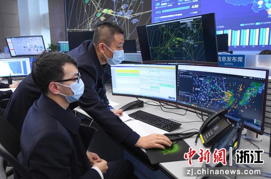 周得博（右）在杭州萧山国际机场联合指挥中心内和同事协调机场航班。王刚 摄