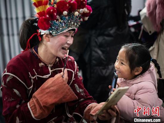 汉寨侗戏班演员与小孩互动。　金可文 摄