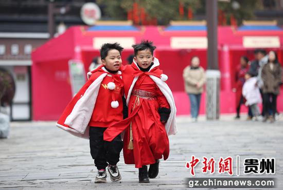 穿着新衣的小孩子在贵州省黔东南苗族侗族自治州丹寨县万达小镇景区游玩。