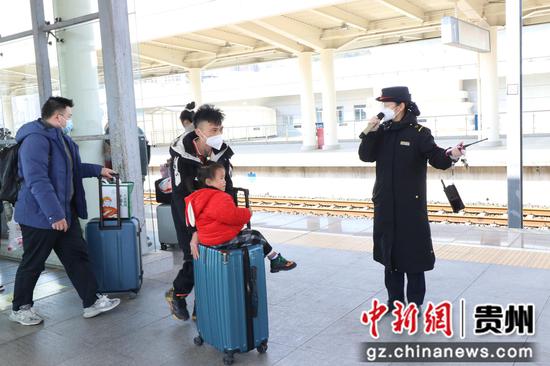 刘珍华在站台楼梯口引导旅客。彭亮摄