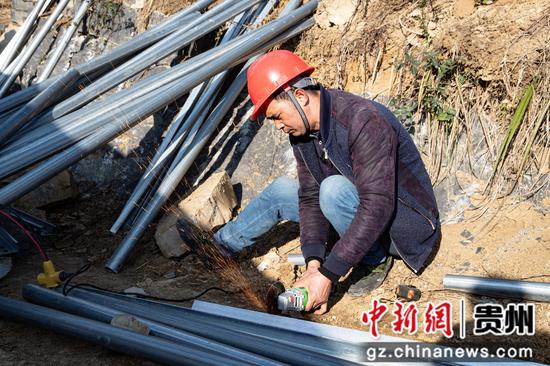 2023年1月30日，贵州省黔西市定新一期农业光伏电站项目施工现场，建设者在切割材料。