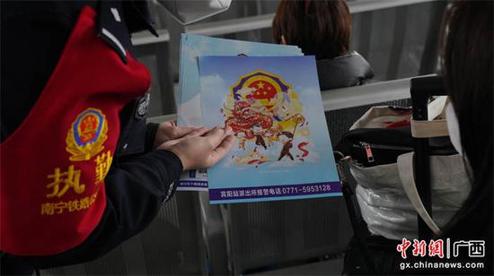 图为民警自绘炮龙节漫画向乘客开展安全宣传。姚鹏鹏  摄