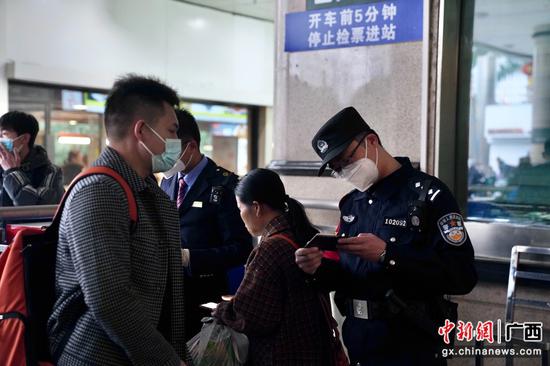 韦柳生在进站口检查旅客的证件。陈思安摄