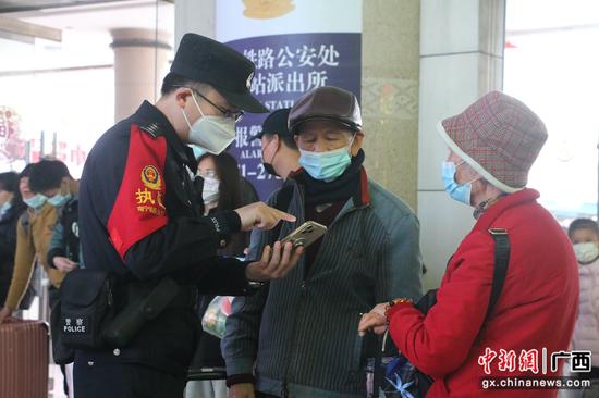 图七:韦柳生帮助旅客查看车次。吴骆霞摄
