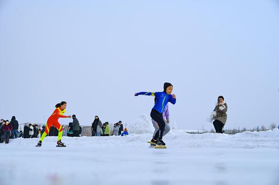 2月6日 參加新疆昌吉回族自治州呼圖壁縣中小學速度滑冰比賽的選手在賽道上馳騁。（陶維明 攝）