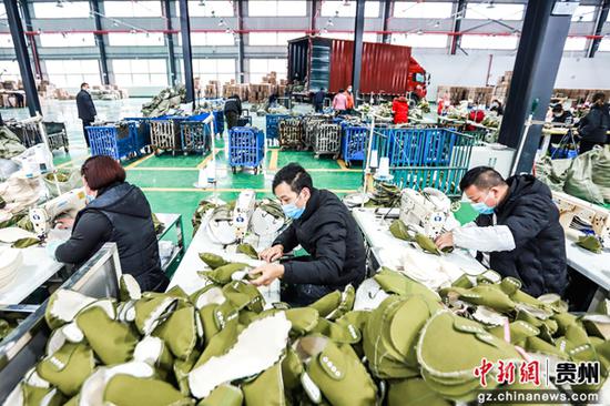 七星关区经济开发区贵州陆海龙腾鞋业有限公司生产车间，工人正在赶制订单。陈曦 摄