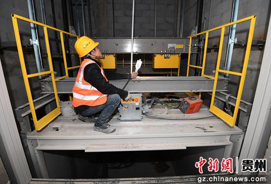 2月9日，在贵阳市南明区南明智能制造产业园三期项目建设现场，中铁八局集团第三工程有限公司的工人正在进行电梯安装调试。