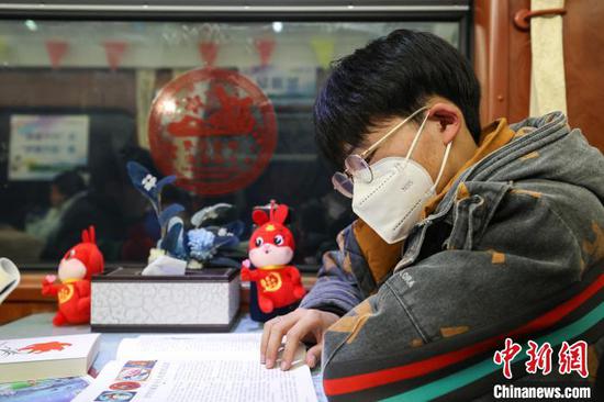 一位来自贵州毕节的学生旅客在“列车书吧”阅读书籍。　瞿宏伦 摄