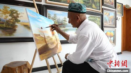 阿卜力克木·麦麦提敏在画一幅关于沙漠胡杨的作品。　隋致远 摄