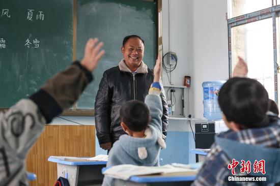 2月15日，杨朝俊在一年级语文课上和学生互动。
