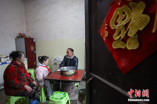 2月15日，杨朝俊（右）在二年级学生张雪瑶家中家访。