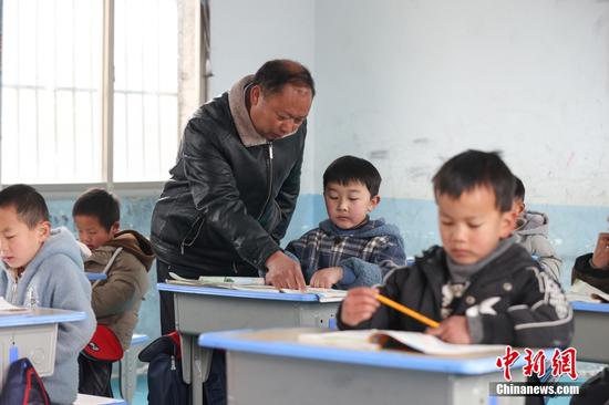 2月15日，杨朝俊在一年级语文课上辅导学生。