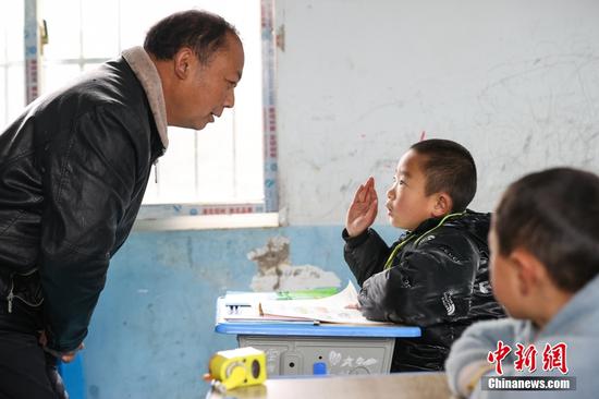 2月15日，杨朝俊在一年级语文课上和学生交流。