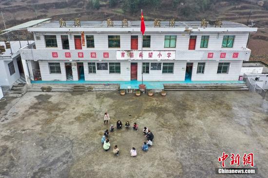 2月15日，杨朝俊和青年教师吉庆华、杨海在中午休息时与学生做游戏。（无人机照片）