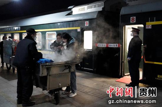 K4178次列车旅客在站台上购买食物。沈向全 摄