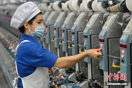 2023年1月，新疆泰昌实业有限责任公司棉纺厂员工正进行生产工序作业。确·胡热 摄2023年1月，新疆泰昌实业有限责任公司棉纺厂员工正进行生产工序作业。确·胡热 摄