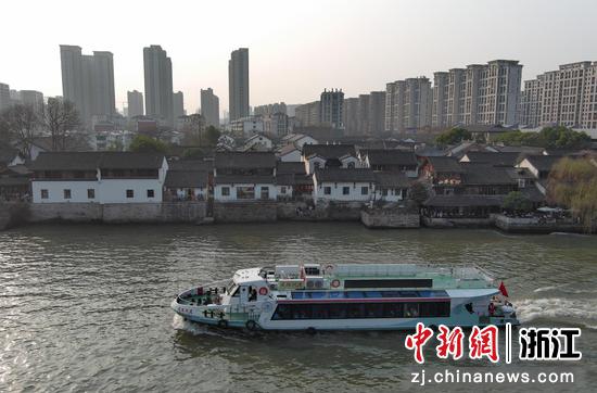 一艘客船从桥西历史文化街区前的中国大运河驶过。（无人机照片）王刚 摄