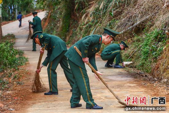 武警官兵打扫山区沿路落泥。