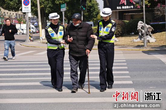 女交警帮助老人过马路。   贺瑞明（通讯员） 摄