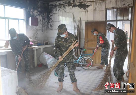 图为武警官兵深入敬老院进行卫生打扫。