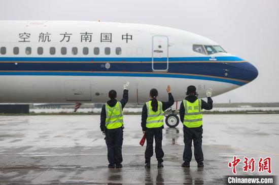 3月7日，范后莎(中)和同事向出港航班挥手再见。　瞿宏伦 摄